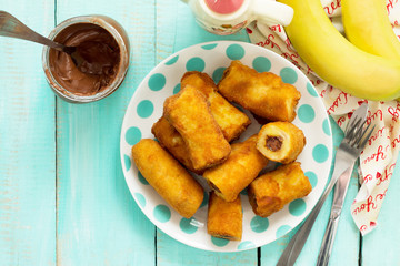 Homemade dessert of fried bananas fried stuffed with chocolate. Copy space, top view flat lay background.