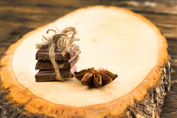 Pieces of chocolate, cinnamon, mint and star anise on the serving Board.