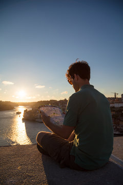 Man reading map at sunset in Porto, Portugal