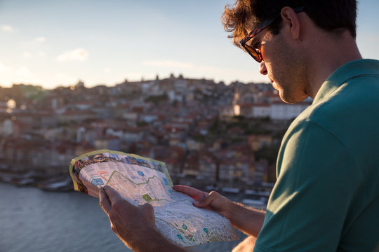 Man looking at tourist map at sunset in Porto, Portugal