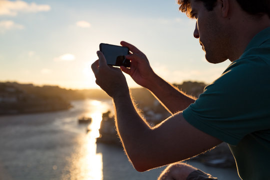 Man takes a sunset photograph of Porto, Portugal