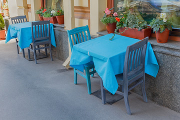 Tables of a street cafe with a blue tablecloth. City