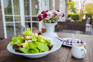 Fresh vegetable caesar salad in white bowl