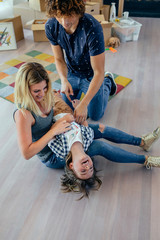 Parents tickling their son on a break from moving