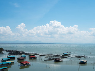 Fototapeta premium Home stay floating house in lake at Kohyo, Songkhla, Thailand with beautiful blue sky and clouds. This is traditional fisheries area.
