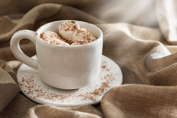 Hot chocolate or cocoa with marshmallows in a white cup with daylight. Sweet hot beverage. Copy space.