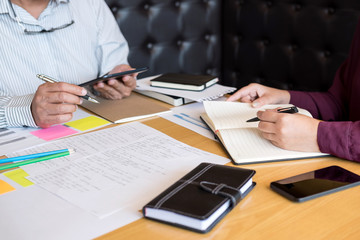 Education, teaching, learning, technology and people concept. Two high school students or classmates with helps friend catching up workbook learning in classroom, Tutor books with friends