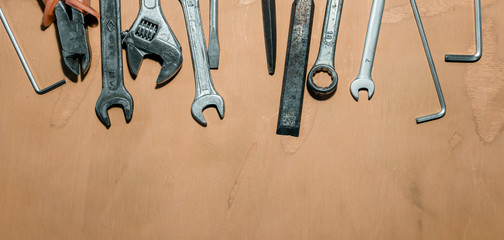 Older tools are laid out in a row on background of the old wooden floor.