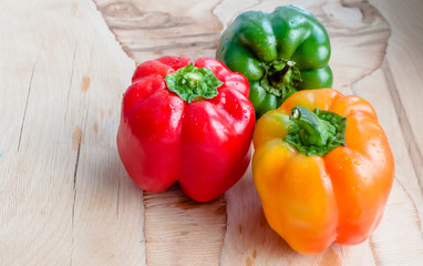 Assorted colorful varieties of bulgarian peppers sitting on old wooden table