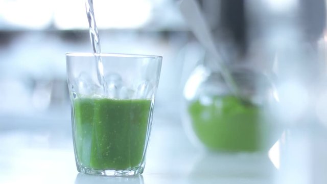 water pouring in glass with matcha powder