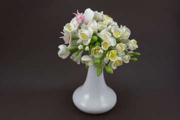 Hand made polymer clay flower bouquet in a white vase on a dark background