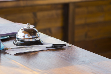 hotel reception bell with pen on counter