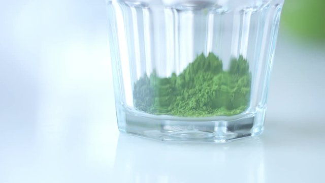 transparent glass with matcha tee powder in it