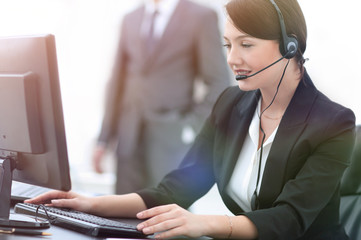 smiling female customer support phone operator at workplace.