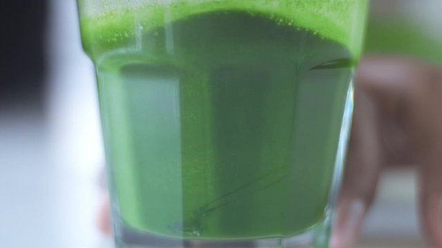 strong green matcha tee in transparent glass preparation process