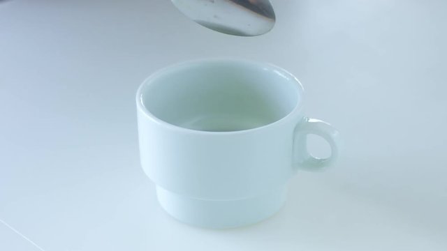 slow motion of matcha tee powder falling in white cup