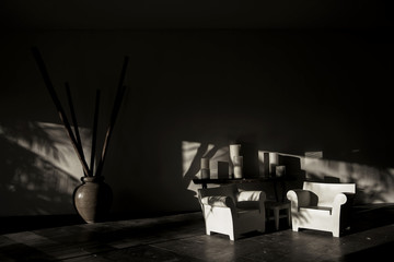Light and shadow of table, chairs, vase, candles and walls. Black and white tone