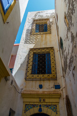 Typical walls of houses with blue windows and iron-shod grille. in the UNESCO protected old arabic town of Essaouira, Morocco, Africa..