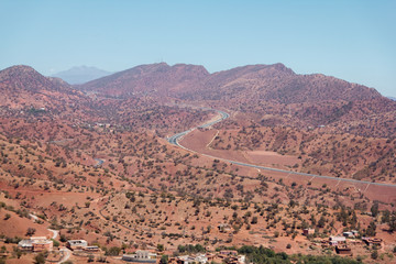 Winding road with trees in red Atlas Mountains, Morocco, Africa.