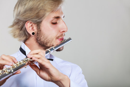 Male flutist playing his flute