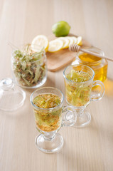 herbal tea with lemon and honey in a glass on a dark light background