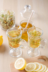 herbal tea with lemon and honey in a glass on a dark light background