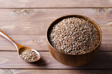 flax seeds in wooden bowl on rustic background