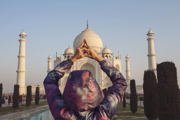 Woman tourist doing yoga mudra infront of Taj Mahal, India