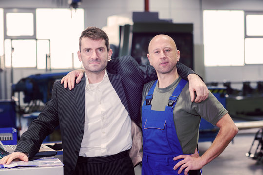 boss and worker on work bench- hugging