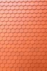 Fragment of a red roof of a private house made of shingles