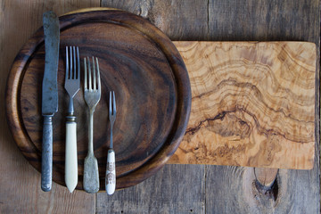 Stainless steel cutlery on a wooden chopping board