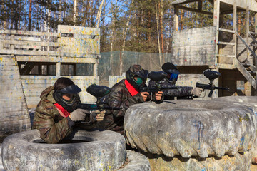 Paintball team in hiding behind the big wheels