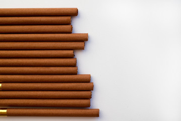Brown cigarettes on white background. View from above