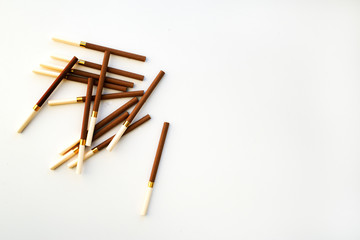Brown cigarettes on white background. View from above