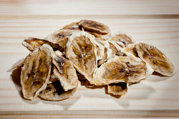 Sliced ripe dried banana cut with mugs on a wooden background