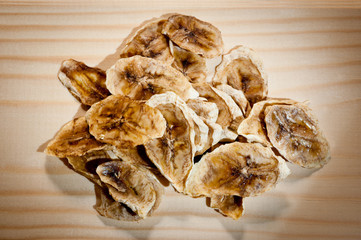 Sliced ripe dried banana cut with mugs on a wooden background