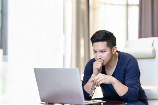 Seriously Confident Asian Young Freelancer In Smart Casual Working And Concentrated On Laptop Sitting On Desk In Modern Office ,co-working Space Or At Home With Copy Space, Webinar Over The Internet