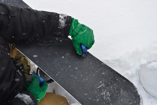 Waxing snowboard surface for better gliding during snowfall