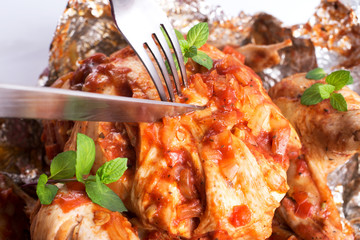 Baked chicken in foil with greens.