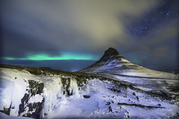 Naklejka premium Colorful Aurora Borealis or better known as The Northern Lights and winter milky way over Kirkjufell, Iceland with starry night milkyway.