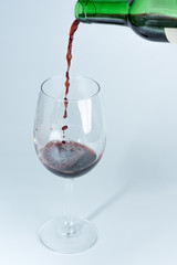 Bottle of red wine serving in wine glass.