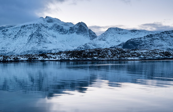 Mountains ridge and reflection on the water surface. Natural landscape in the Norway