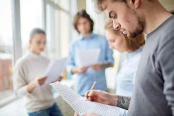 Young businessman concentrated on his report. He is preparing for business seminar