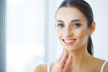 Nutrition. Healthy Lifestyle. Woman Holding Pill With Fish Oil Omega-3. Supplements, Vitamins.