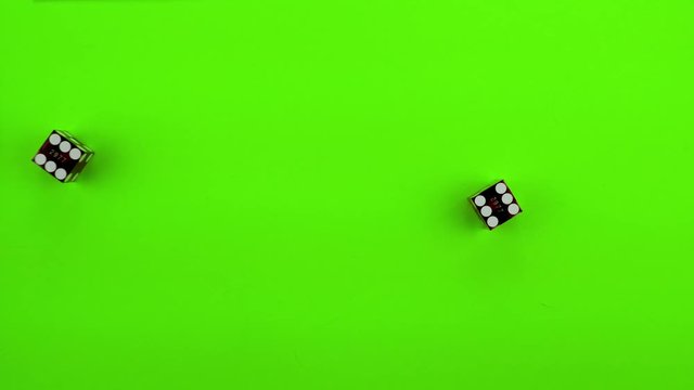 Red casino dice being rolled and settling on craps (double one) on a green screen. Multiple rolls