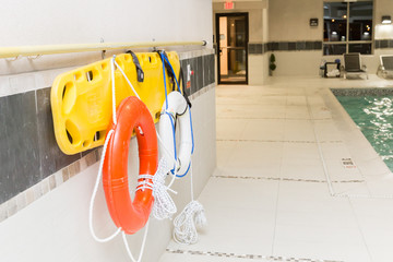 lifebuoy and rescue ring hanging on wall by swimming pool