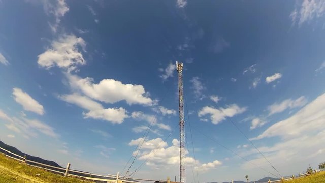 GSM or CDMA Antenna on a blue sky background, timelapse.