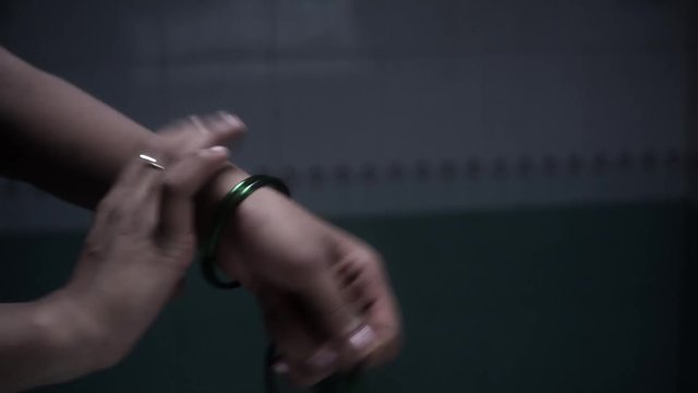 Young girl taking off bangles at bathroom