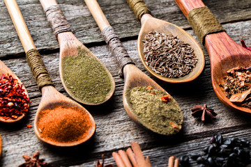 Spices for cooking with kitchen accessories on an old background