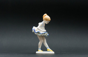 Little balerina girl - porcelain figurine on black background © Menta